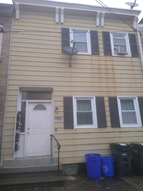 A house with a white door and two windows with black shutters.
