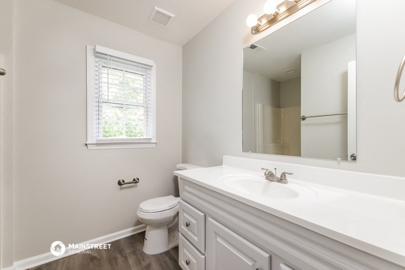 a bathroom with a large mirror and a sink and a toilet