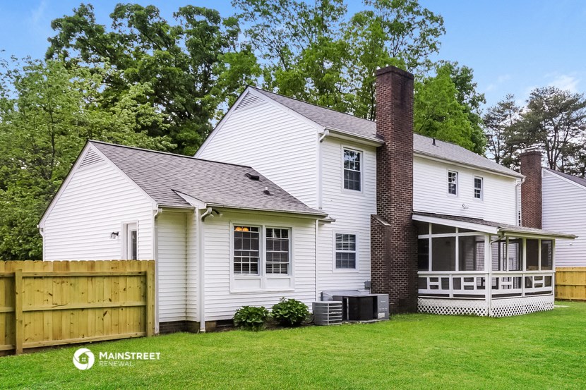 a white house with a yard and a wooden fence