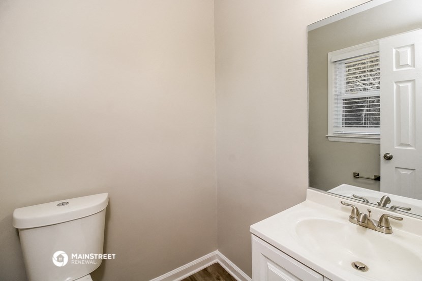 a bathroom with a toilet and a sink and a mirror