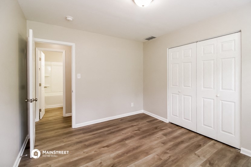 a bedroom with two closets and a door to a hallway