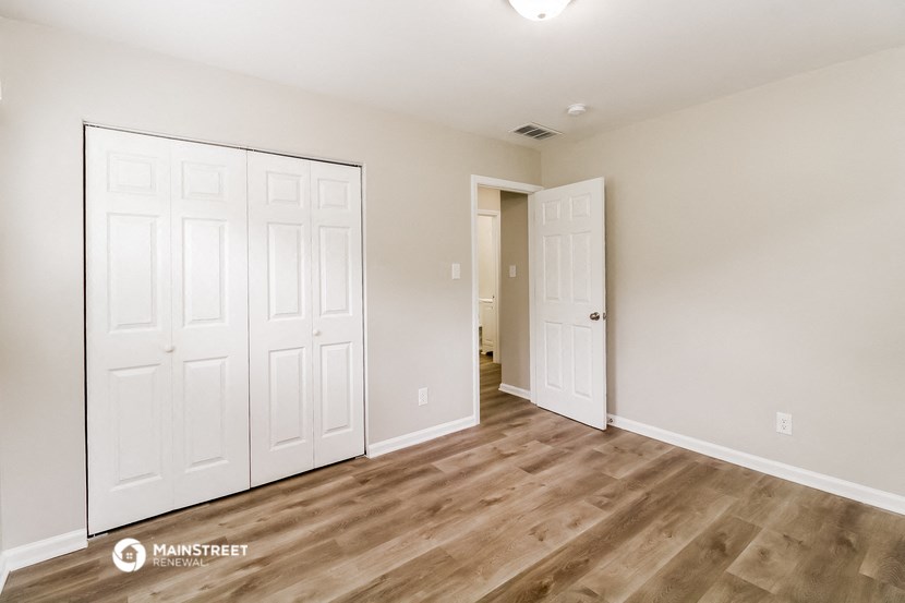 a bedroom with two closets and a door to a hallway