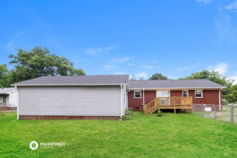 the front of a house with a yard and a deck