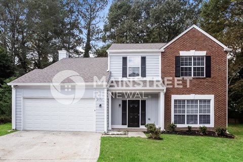 a house with a white garage and a brick house