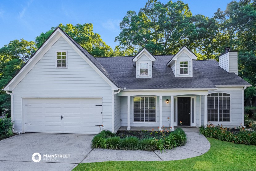 a white house with two dormers and a driveway