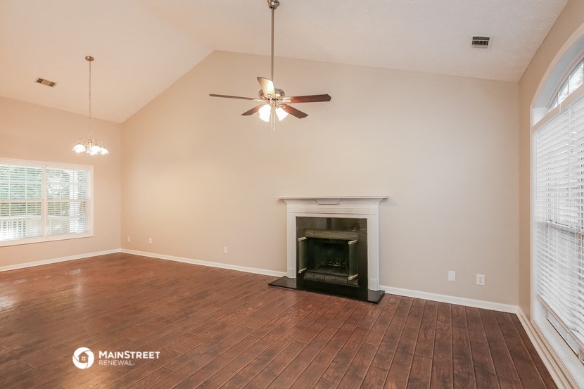 the living room with wood flooring and a fireplace