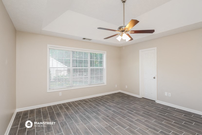 the spacious living room with tile flooring and a ceiling fan