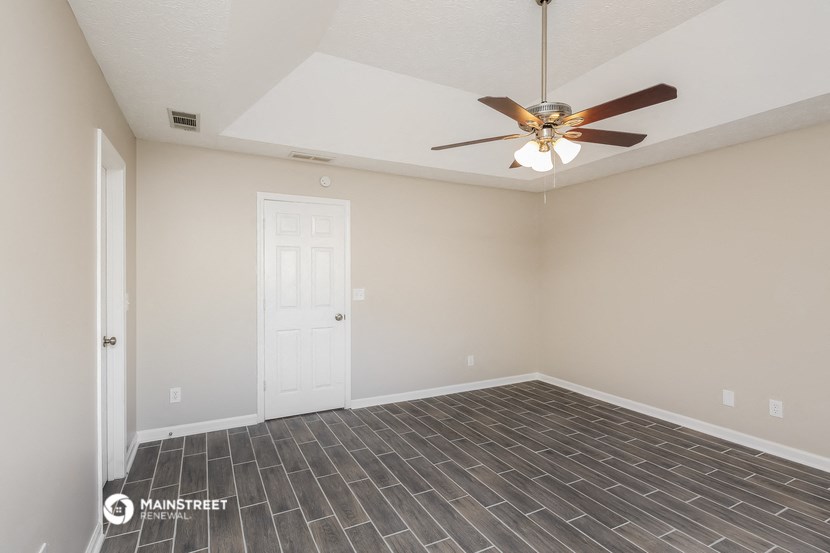 the spacious living room with tile flooring and a ceiling fan