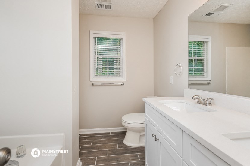 a bathroom with a toilet and a sink and a mirror