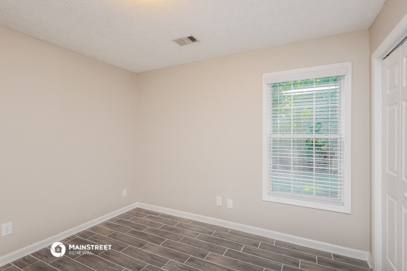 the living room of a house with a window and a tiled floor