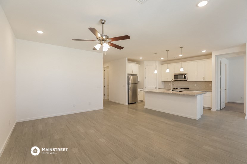 an open kitchen and living room with a ceiling fan
