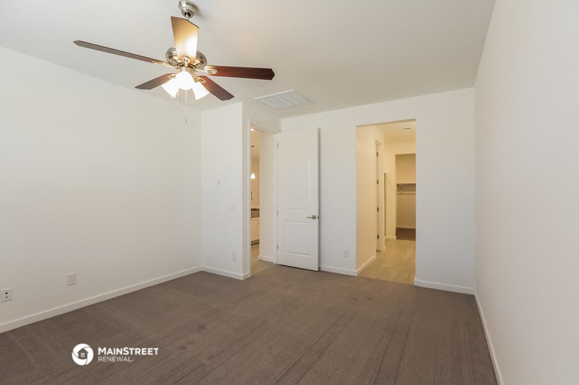 a living room with a ceiling fan and white walls