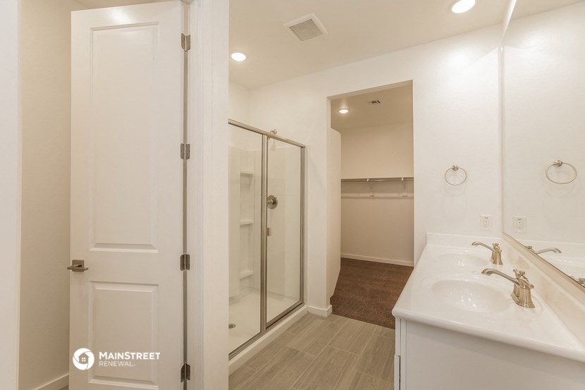 a white bathroom with a shower and a sink