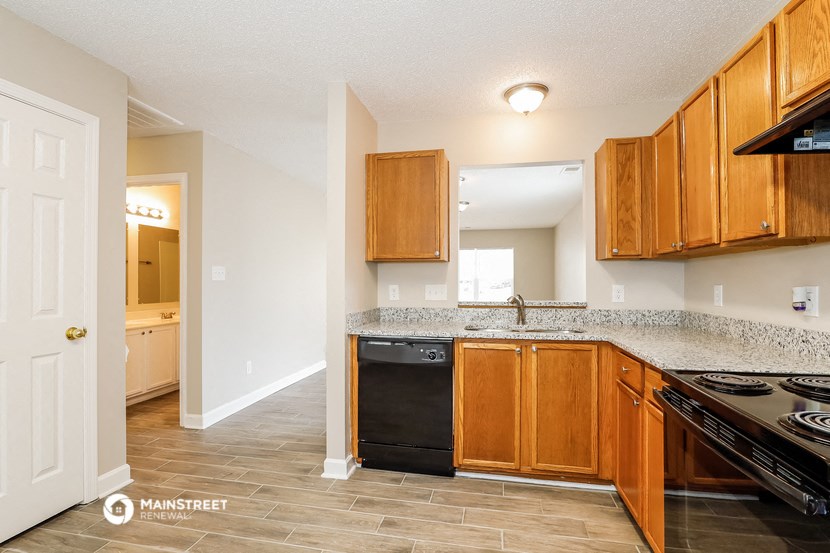 the kitchen is clean and ready to use with wood cabinets and black appliances