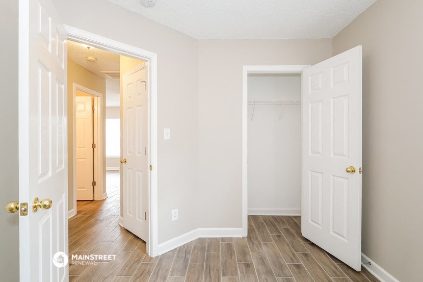 a bedroom with two closets and a hallway with a door to a closet