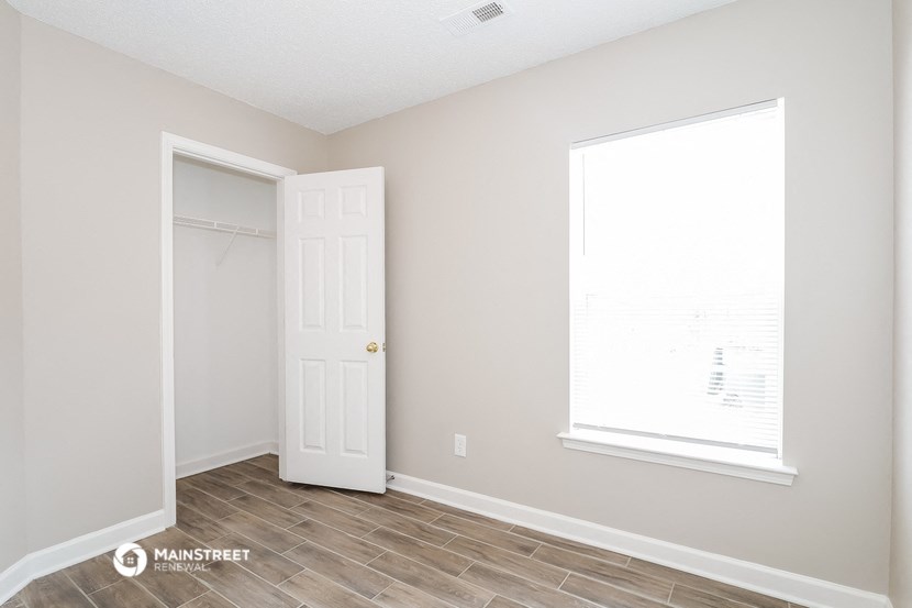 a bedroom with a closet and a door and a window