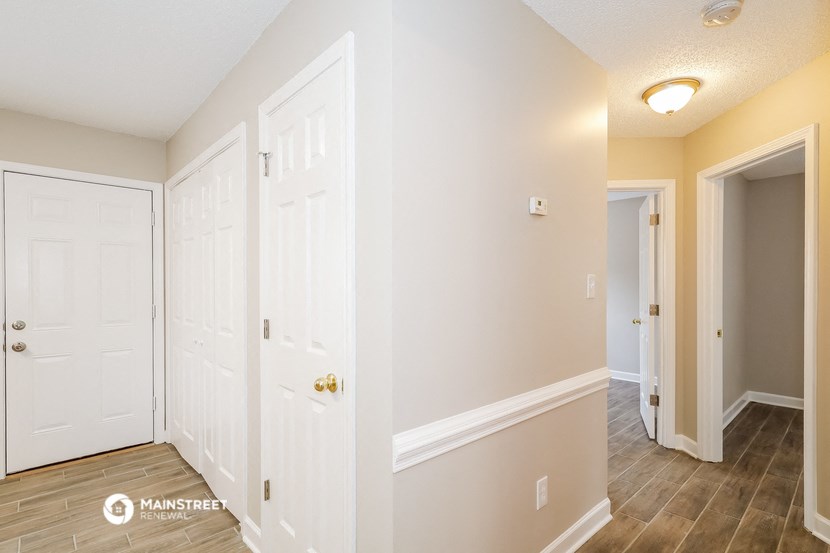a bedroom with two doors and a hallway with a door to a closet