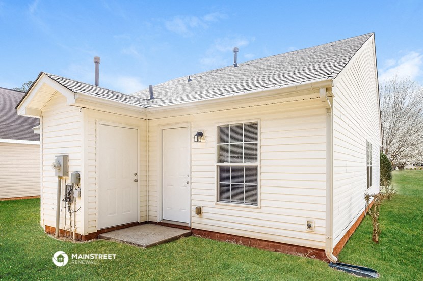a small white house with two closets and a lawn
