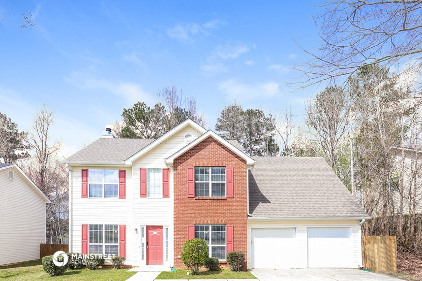 a white house with red shutters and a roof