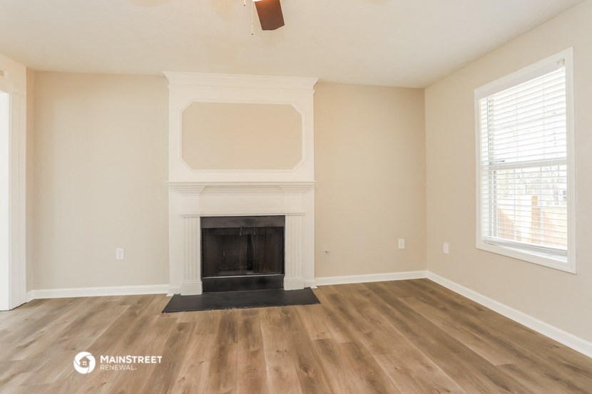 the living room with fireplace and wood flooring