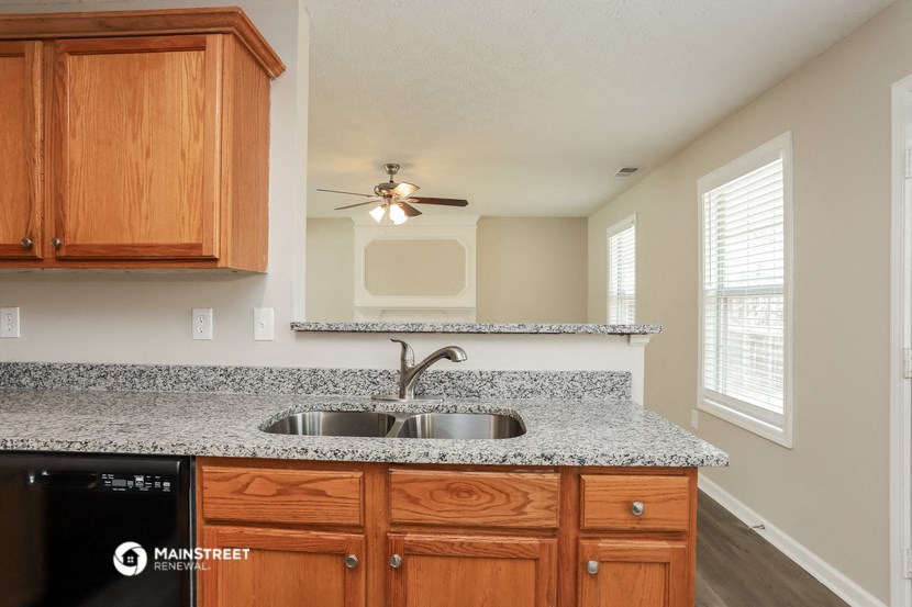 the kitchen has granite counter tops and wooden cabinets