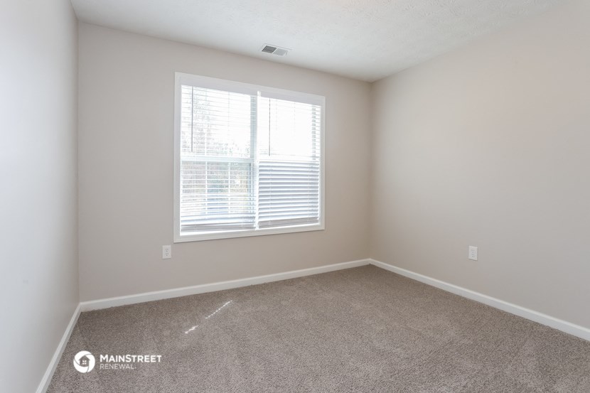 a spacious room with carpet and a large window