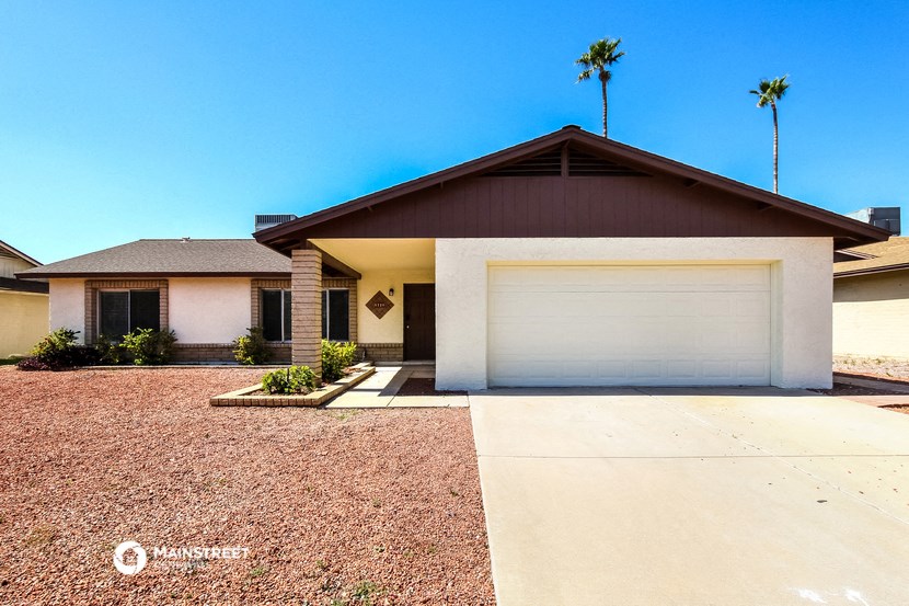 a white house with a garage door and a driveway
