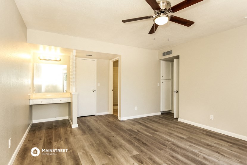 a living room with wood flooring and a ceiling fan