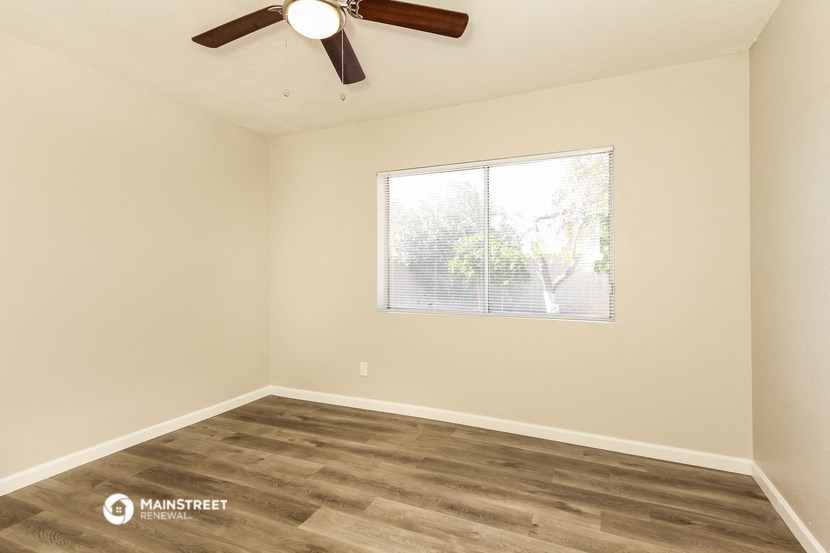 a living room with a window and a ceiling fan