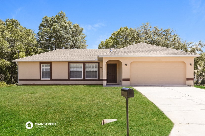 a beige house with a lawn and a parking meter