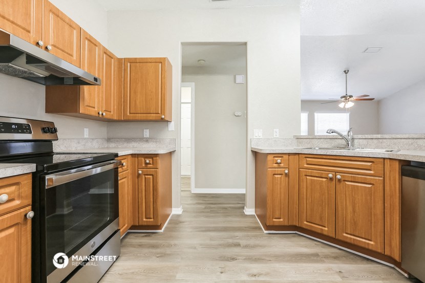 a kitchen with wooden cabinets and a stove and a sink