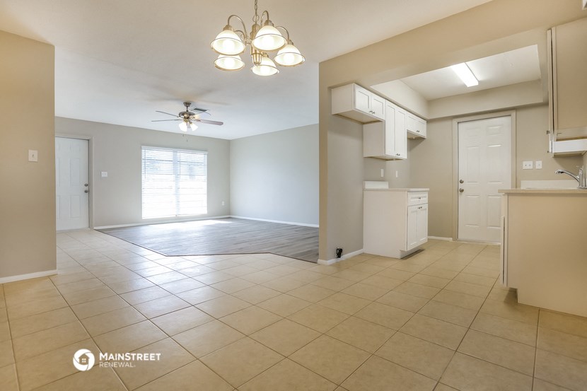 an empty kitchen and living room with a ceiling fan