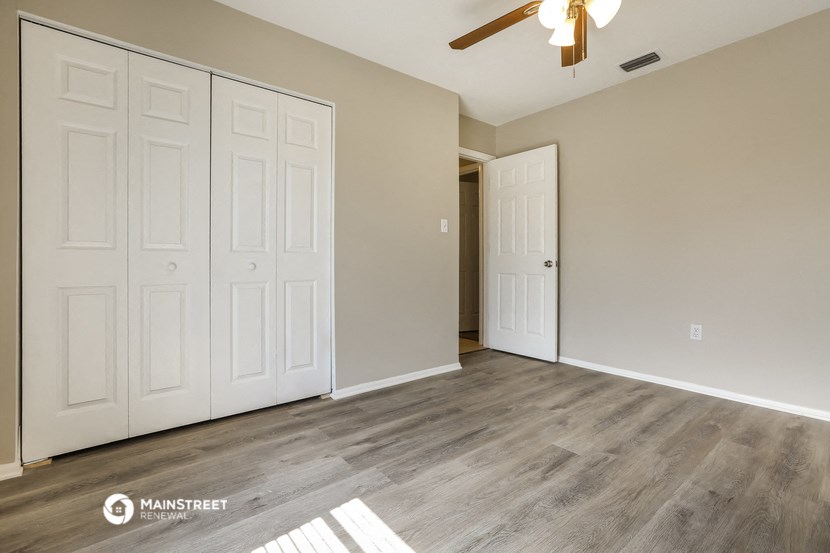 the living room of a new home with white doors and a ceiling fan