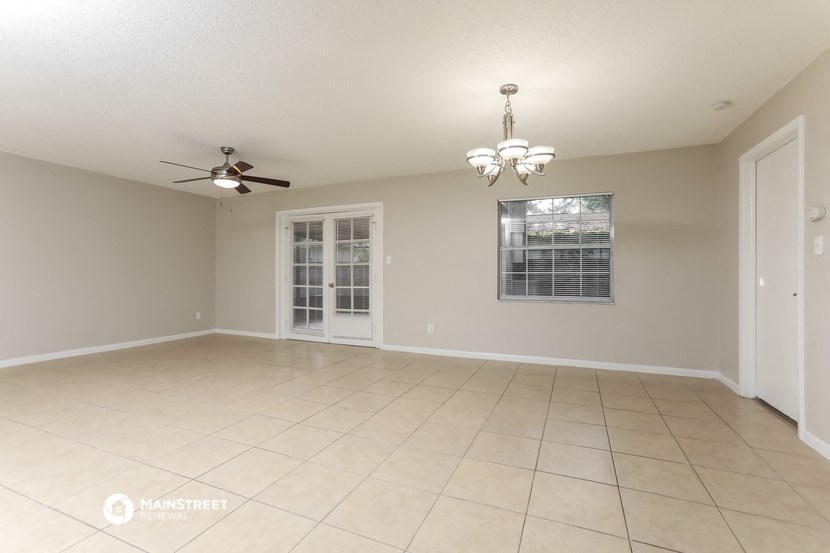 an empty living room with a ceiling fan