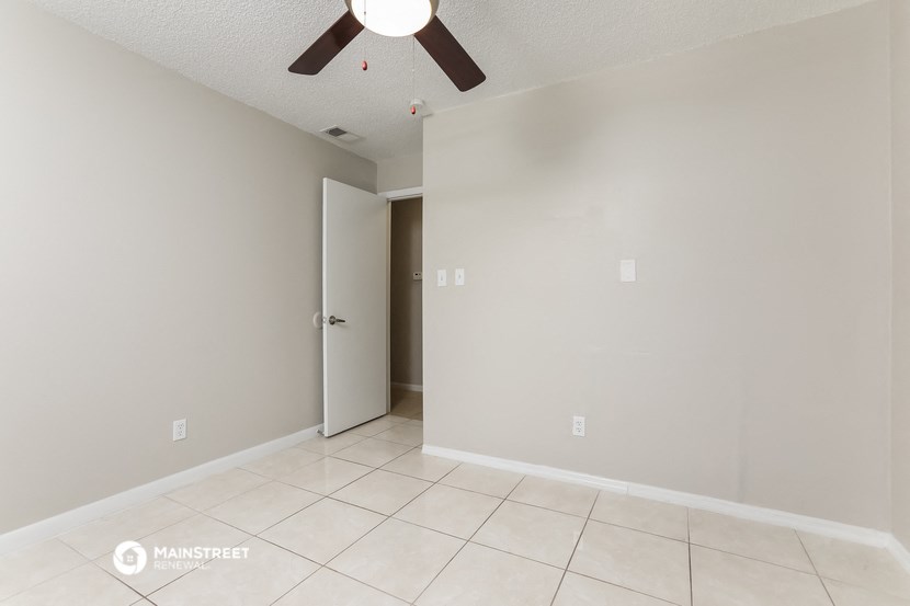 the living room of an empty house with a ceiling fan