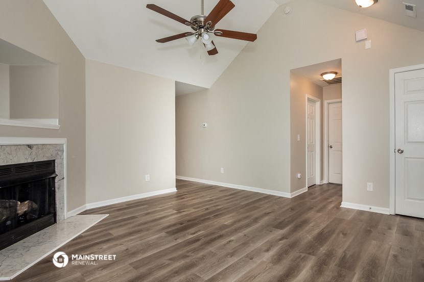 a living room with a fireplace and a ceiling fan