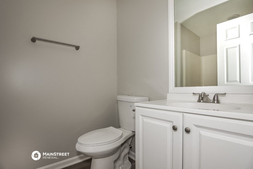 a white bathroom with a toilet and a sink