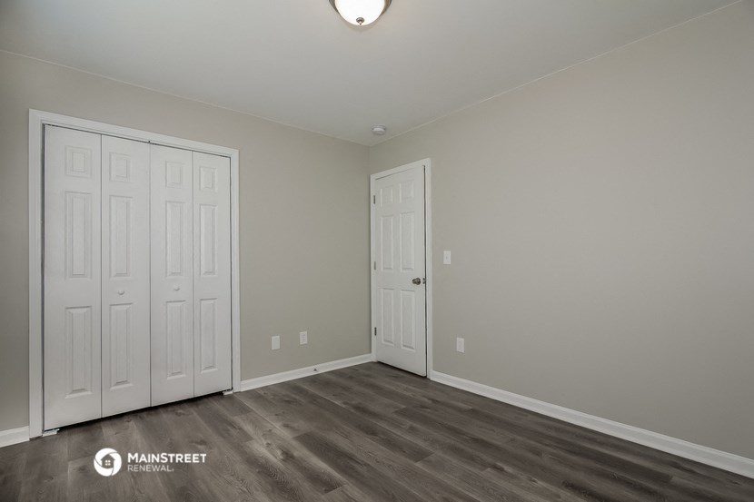a bedroom with two doors and a door to a closet
