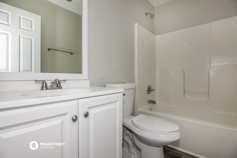 a bathroom with a sink toilet and a mirror