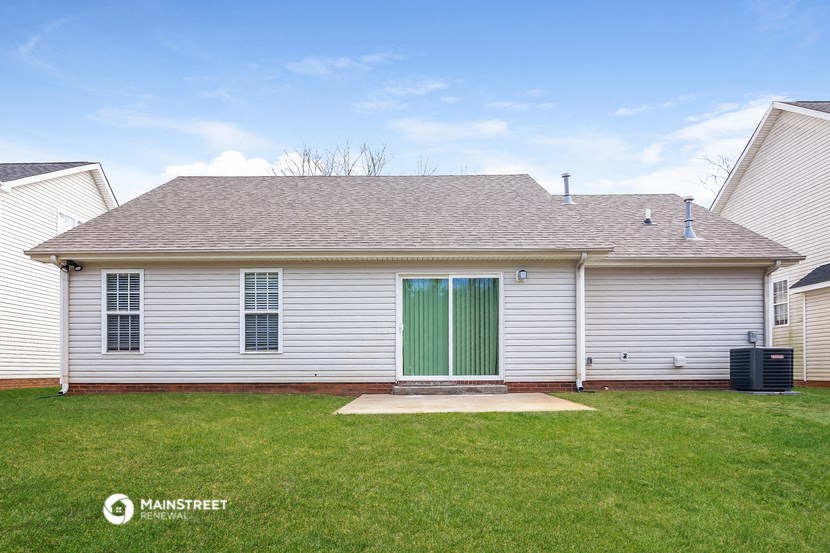 a white house with a green door on a grass yard