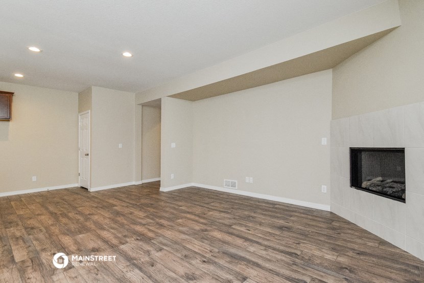 a living room with a fireplace and a wooden floor