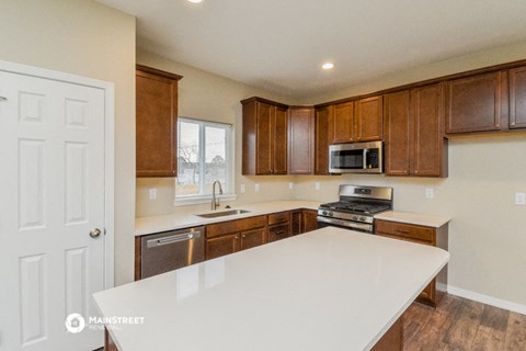a kitchen with a white counter top and wooden cabinets