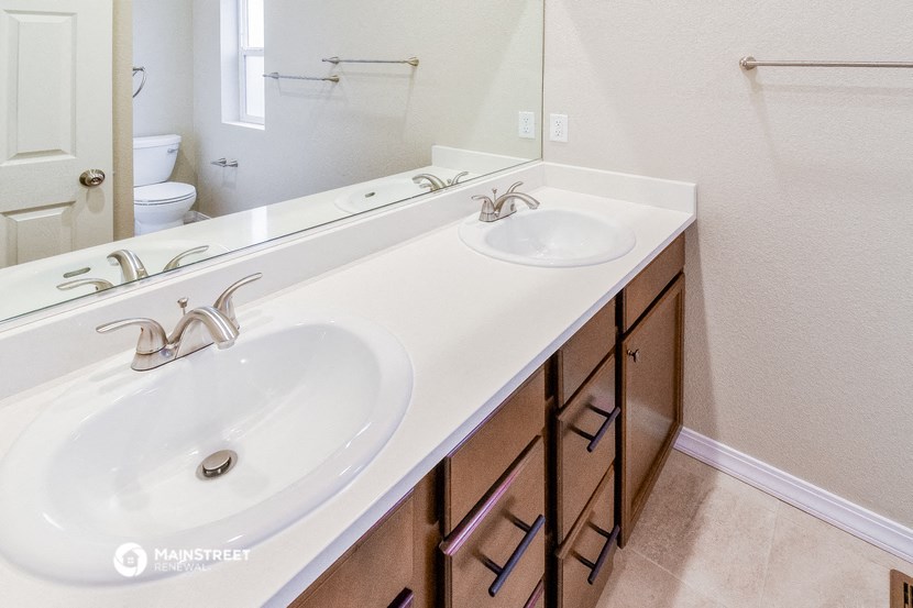 a bathroom with two sinks and a mirror