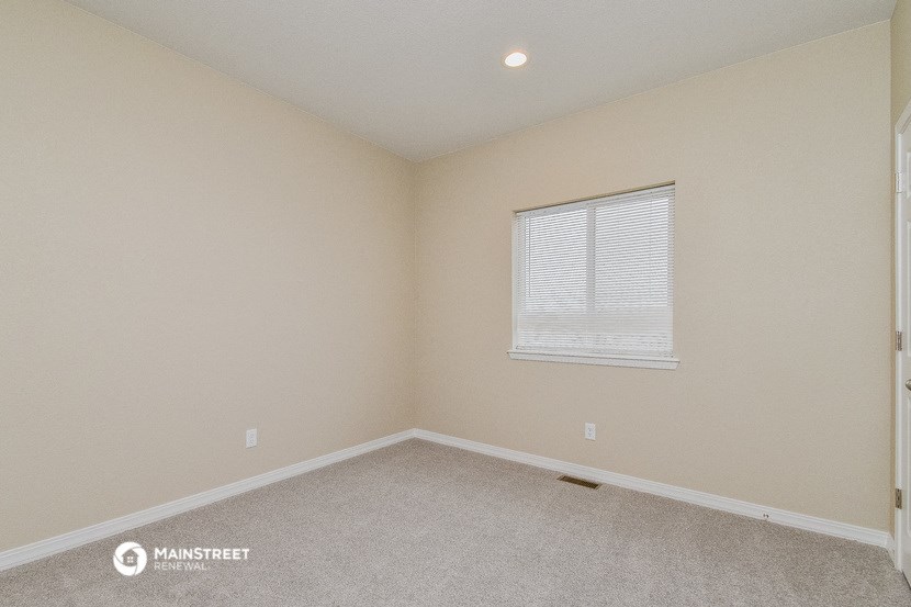 an empty room with a window and a carpet