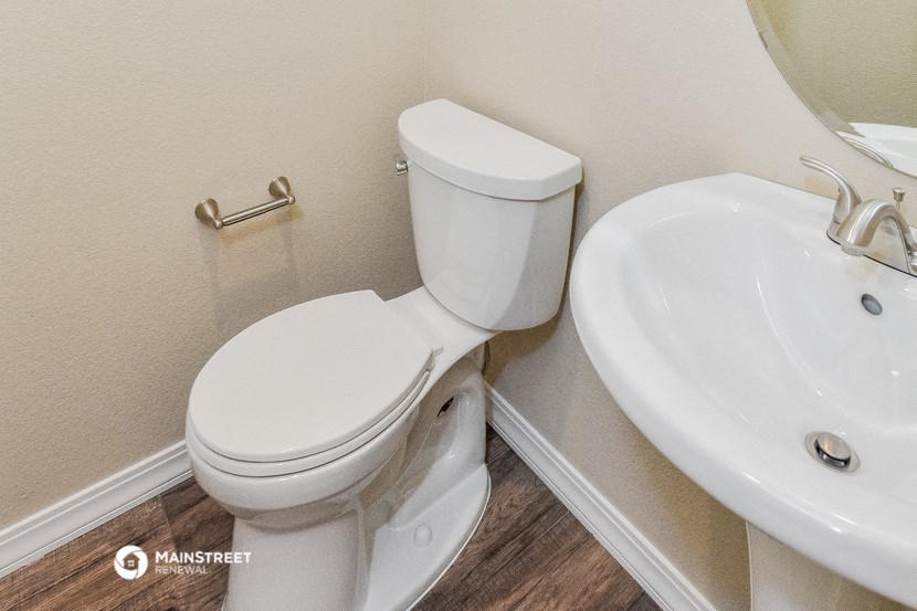a white toilet and a sink in a bathroom
