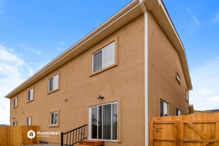 the outside of a house with a wooden fence