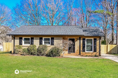 a small brick house with a yard in front of it