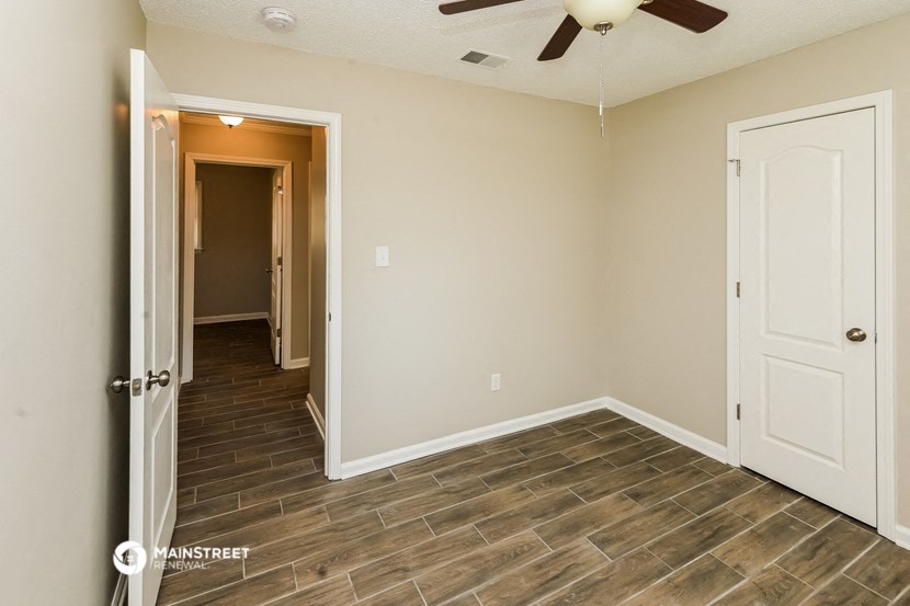 the living room of a home with a wood floor and a ceiling fan