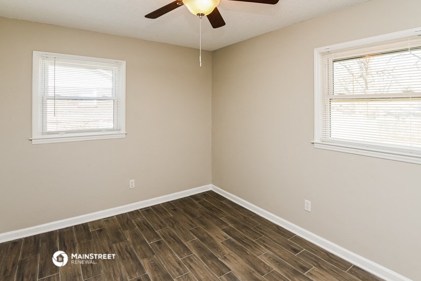 the bedroom of our studio apartment atrium with wood flooring and a ceiling fan