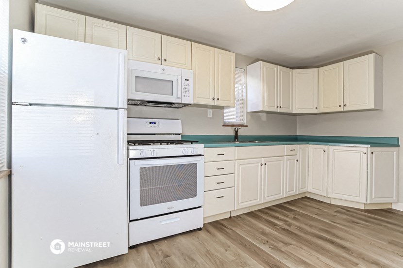 a kitchen with white appliances and white cabinets and a white refrigerator